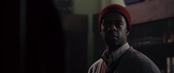 Movie still from “The Day After Tomorrow” (2004), directed by Roland Emmerich – A man wearing a red hat standing in a room; Close Up shot, Over the shoulder angle
