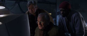 Movie still from “The Day After Tomorrow” (2004), directed by Roland Emmerich – A group of men looking at a computer screen; Medium shot, Low angle