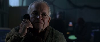 Movie still from “The Day After Tomorrow” (2004), directed by Roland Emmerich – An older man wearing glasses and a sweater; Close Up shot, Low angle