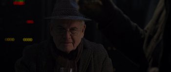 Movie still from “The Day After Tomorrow” (2004), directed by Roland Emmerich – An older man wearing glasses and a hat; Close Up shot, Over the shoulder angle