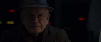 Movie still from “The Day After Tomorrow” (2004), directed by Roland Emmerich – An older man wearing a hat and glasses; Close Up shot, Over the shoulder angle