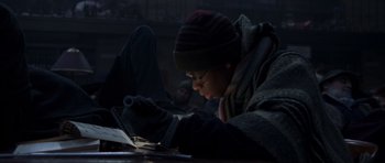 Movie still from “The Day After Tomorrow” (2004), directed by Roland Emmerich – A man is looking at a book on a laptop; Medium shot, Low angle