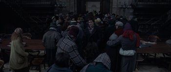 Movie still from “The Day After Tomorrow” (2004), directed by Roland Emmerich – A group of people standing around in a building; Medium shot, Over the shoulder angle
