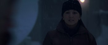 Movie still from “The Day After Tomorrow” (2004), directed by Roland Emmerich – A woman wearing a jacket and a hat standing in the snow; Close Up shot, Low angle