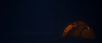 Movie still from “The Day After Tomorrow” (2004), directed by Roland Emmerich – An orange tent in the middle of the night with power lines in the background; Extreme Wide shot, High angle