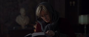 Movie still from “The Day After Tomorrow” (2004), directed by Roland Emmerich – A woman reading a book while wearing glasses and a scarf; Close Up shot, Low angle