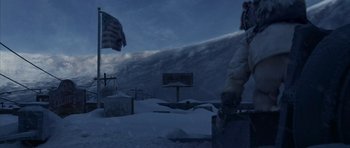 Movie still from “The Day After Tomorrow” (2004), directed by Roland Emmerich – A man standing in the snow next to an american flag; Extreme Wide shot, Low angle