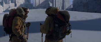 Movie still from “The Day After Tomorrow” (2004), directed by Roland Emmerich – A man with a backpack is standing in front of a city skyline; Wide shot, High angle
