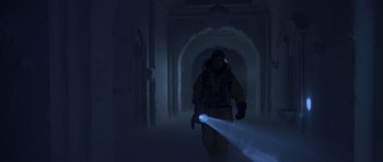 Movie still from “The Day After Tomorrow” (2004), directed by Roland Emmerich – A man is holding a flashlight while walking in a dark room; Wide shot, Low angle