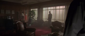 Movie still from “The Day After Tomorrow” (2004), directed by Roland Emmerich – A man standing in front of a window in a living room; Wide shot, Low angle