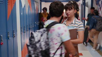 Movie still from “Crush” (2022), directed by Sammi Cohen – A girl is talking to another girl in a hallway; Medium shot, Over the shoulder angle