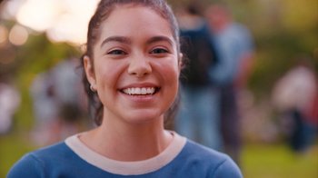 Movie still from “Crush” (2022), directed by Sammi Cohen – A person smiling; Close Up shot, Over the shoulder angle