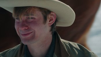 Movie still from “The Desperate Riders” (2022), directed by Michael Feifer – A person wearing a cowboy hat; Close Up shot, Over the shoulder angle