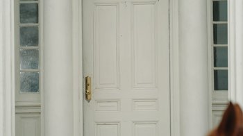 Movie still from “The Desperate Riders” (2022), directed by Michael Feifer – A white door with two panels and a brass handle; Wide shot, High angle