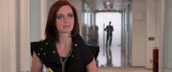 Movie still from “The Devil Wears Prada” (2006), directed by David Frankel – A woman with red hair wearing a black jacket; Medium shot, Over the shoulder angle