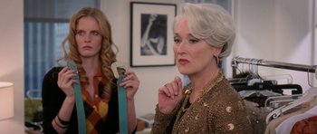 Movie still from “The Devil Wears Prada” (2006), directed by David Frankel – Two women in a room with a picture on the wall behind them; Medium shot, Over the shoulder angle