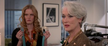 Movie still from “The Devil Wears Prada” (2006), directed by David Frankel – Two women in a room with a picture on the wall behind them; Close Up shot, Over the shoulder angle
