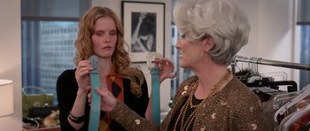 Movie still from “The Devil Wears Prada” (2006), directed by David Frankel – Two women are looking at each other holding a pair of blue bracelets; Close Up shot, Over the shoulder angle