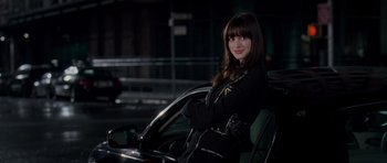 Movie still from “The Devil Wears Prada” (2006), directed by David Frankel – A woman sitting in the driver's seat of a car at night; Medium shot, Over the shoulder angle