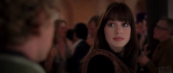 Movie still from “The Devil Wears Prada” (2006), directed by David Frankel – A woman's face in front of a group of people; Close Up shot, Over the shoulder angle