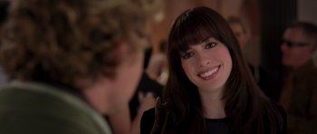 Movie still from “The Devil Wears Prada” (2006), directed by David Frankel – A person smiling at the camera; Close Up shot, Over the shoulder angle