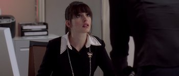 Movie still from “The Devil Wears Prada” (2006), directed by David Frankel – A woman in a black shirt and a white collar; Medium shot, Over the shoulder angle