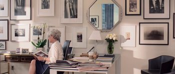 Movie still from “The Devil Wears Prada” (2006), directed by David Frankel – A woman sitting at a desk in front of a mirror; Medium shot, Over the shoulder angle