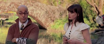 Movie still from “The Devil Wears Prada” (2006), directed by David Frankel – A woman standing next to another woman holding a cell phone; Medium shot, Over the shoulder angle