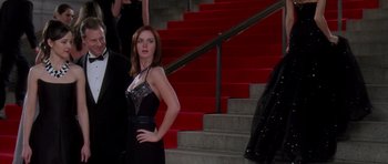 Movie still from “The Devil Wears Prada” (2006), directed by David Frankel – A woman in a black dress standing in front of some steps; Medium shot, Low angle