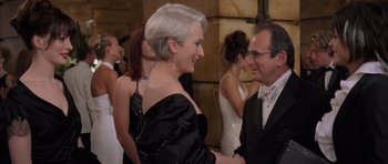 Movie still from “The Devil Wears Prada” (2006), directed by David Frankel – A man and a woman shaking hands in a crowd; Medium shot, Over the shoulder angle
