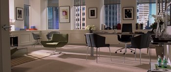 Movie still from “The Devil Wears Prada” (2006), directed by David Frankel – A room filled with chairs and a table in it; Wide shot, High angle