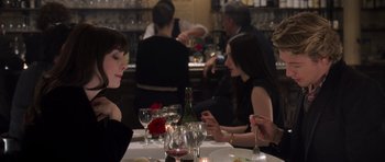 Movie still from “The Devil Wears Prada” (2006), directed by David Frankel – A group of people sitting at a table in a restaurant; Close Up shot, Over the shoulder angle