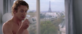 Movie still from “The Devil Wears Prada” (2006), directed by David Frankel – A man holding a nintendo wii game controller in front of a window; Medium shot, Over the shoulder angle