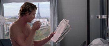 Movie still from “The Devil Wears Prada” (2006), directed by David Frankel – A man is holding papers in front of a window; Medium shot, Over the shoulder angle