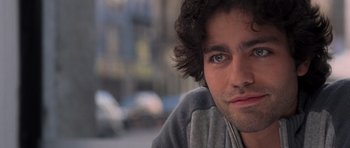 Movie still from “The Devil Wears Prada” (2006), directed by David Frankel – A man's face with a blurry background; Close Up shot, Over the shoulder angle