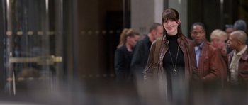 Movie still from “The Devil Wears Prada” (2006), directed by David Frankel – A woman standing next to a group of people in a building; Medium shot, Over the shoulder angle