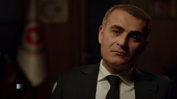 Movie still from “The Dissident” (2020), directed by Bryan Fogel – A person wearing a suit and tie; Close Up shot, Low angle