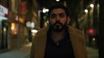 Movie still from “The Dissident” (2020), directed by Bryan Fogel – A man with a beard wearing a brown coat; Close Up shot, Low angle