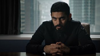 Movie still from “The Dissident” (2020), directed by Bryan Fogel – A man sitting at a table in front of a window; Close Up shot, Low angle