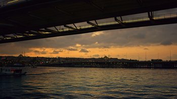 Movie still from “The Dissident” (2020), directed by Bryan Fogel – A view of a city from under a bridge at sunset; Extreme Wide shot, High angle