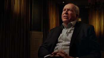 Movie still from “The Dissident” (2020), directed by Bryan Fogel – An older man wearing a suit sitting in front of a window; Close Up shot, Over the shoulder angle