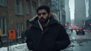 Movie still from “The Dissident” (2020), directed by Bryan Fogel – A man in a black jacket is walking down the street; Close Up shot, Low angle