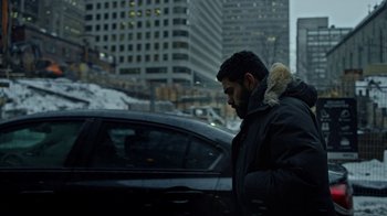 Movie still from “The Dissident” (2020), directed by Bryan Fogel – A man walking in front of a car on a snowy day; Medium shot, Low angle