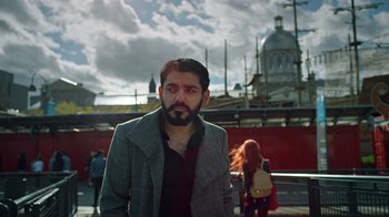 Movie still from “The Dissident” (2020), directed by Bryan Fogel – A man with a beard standing in front of a building; Medium shot, Low angle