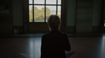 Movie still from “The Dissident” (2020), directed by Bryan Fogel – A woman standing in front of a window looking outside; Medium shot, Low angle