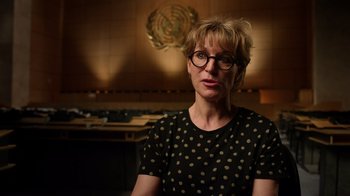 Movie still from “The Dissident” (2020), directed by Bryan Fogel – A woman wearing glasses and a polka dot shirt in a room; Close Up shot, Low angle