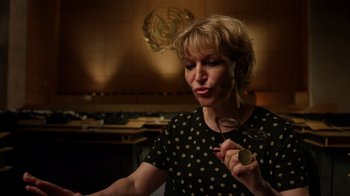 Movie still from “The Dissident” (2020), directed by Bryan Fogel – A woman holding a coin in her hand; Close Up shot, Low angle