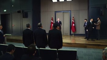 Movie still from “The Dissident” (2020), directed by Bryan Fogel – A man is giving a speech in front of a group of people; Wide shot, Low angle