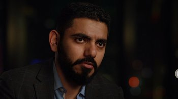 Movie still from “The Dissident” (2020), directed by Bryan Fogel – A person wearing a suit and beard; Close Up shot, Over the shoulder angle