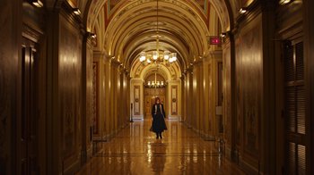Movie still from “The Dissident” (2020), directed by Bryan Fogel – A woman is walking down the hall way of a building; Extreme Wide shot, Low angle